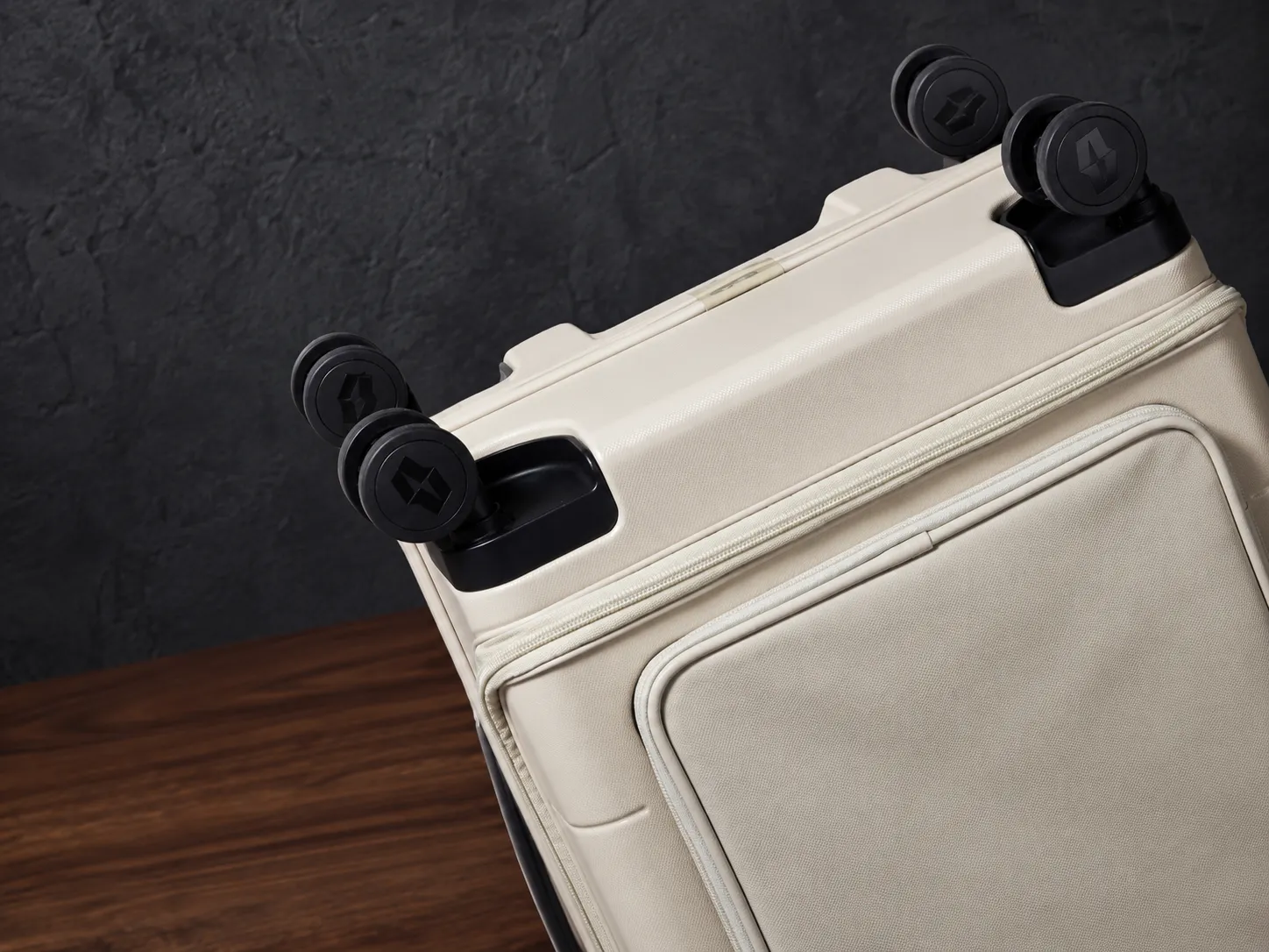 Close-up of the four spinner wheels from below, case tilted mid-turn.